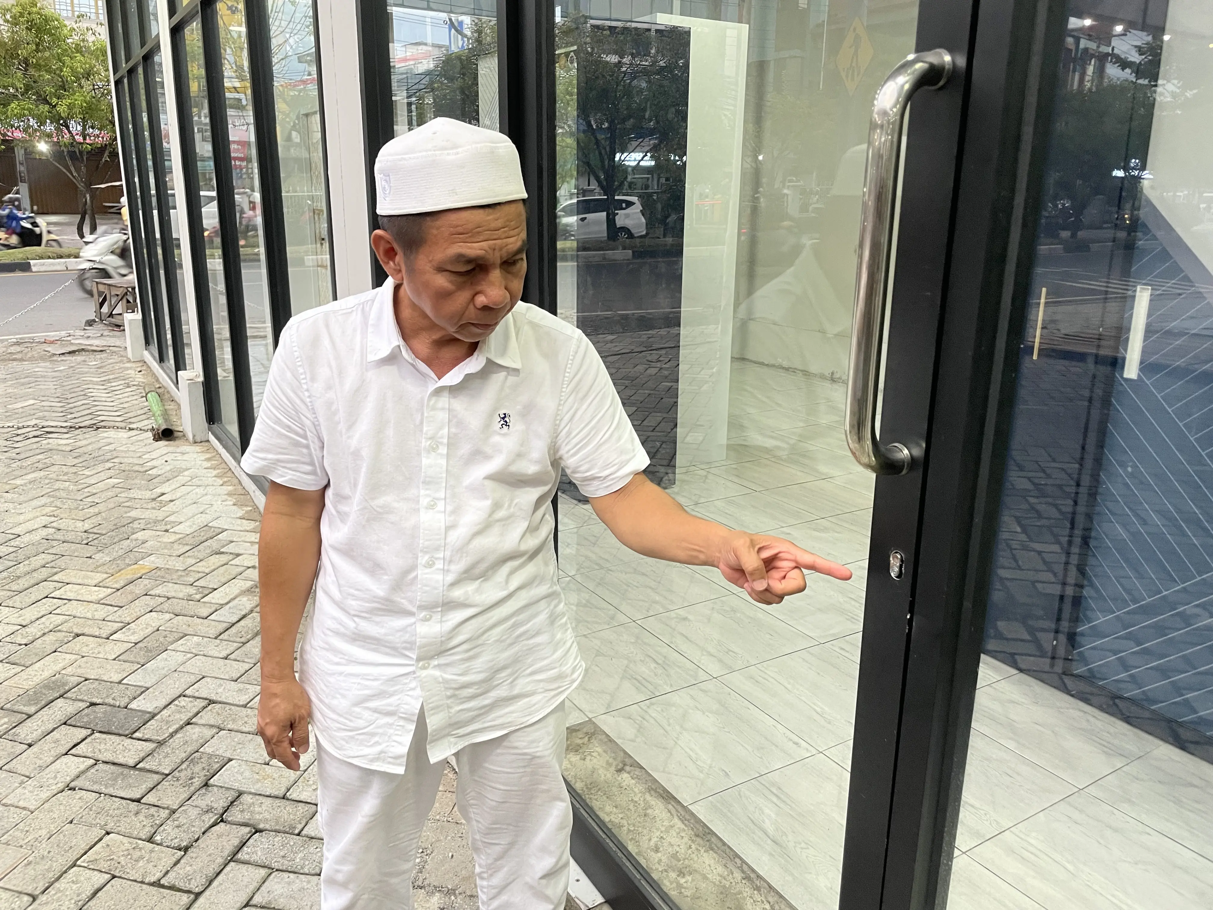 Supian Noor menunjukkan kunci pintu toko mebelnya yang dirusak para pelaku. Foto: Syahbani