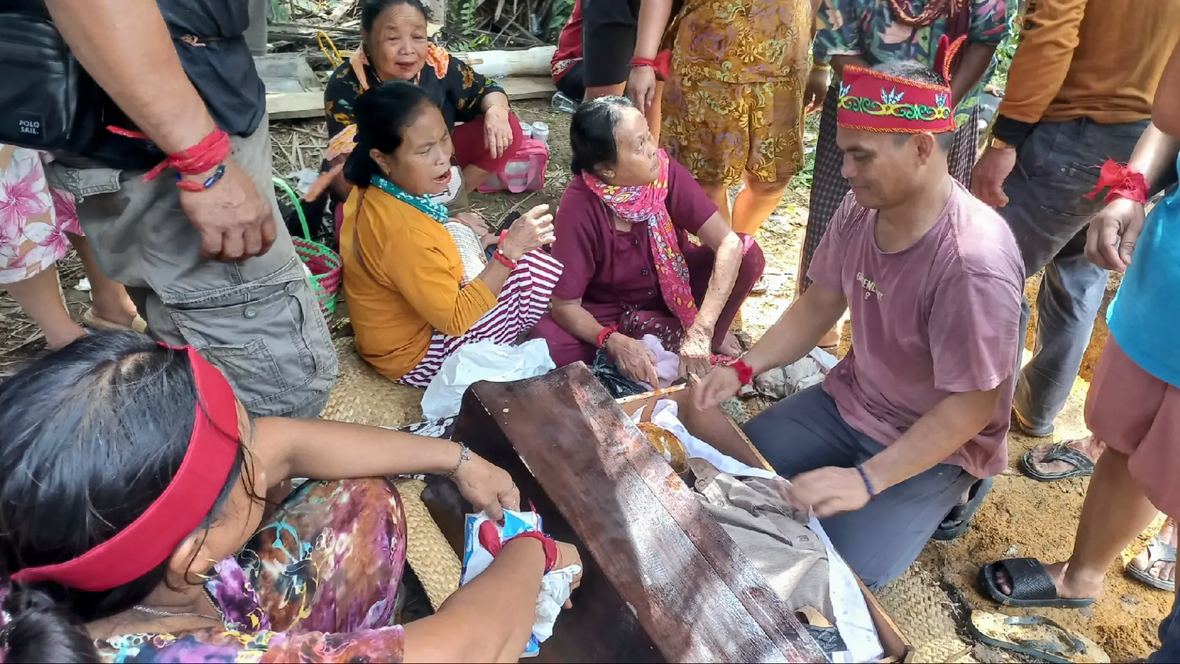 Prosesi Ahli waris atau keluarga sedang membersihkan tulang belulang dan memasukan kedalam peti kecil khusus, dalam ritual Tiwah, di Desa Pundu, Kecamatan Cempaga Hulu. Minggu (21/6/2026). Foto: bakabar.com/ Ilhamsyah Hadi